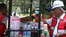 Menteri PUPR, Basuki Hadimuljono membeli kopi yang dijajakan pedagang seusai meninjau renovasi stadion di Gelora Bung Karno (GBK), Jakarta, Kamis (10/5). Basuki meninjau kesiapan fasilitas dan prasarana untuk Asian Games 2018. (Liputan6.com/Angga Yuniar)