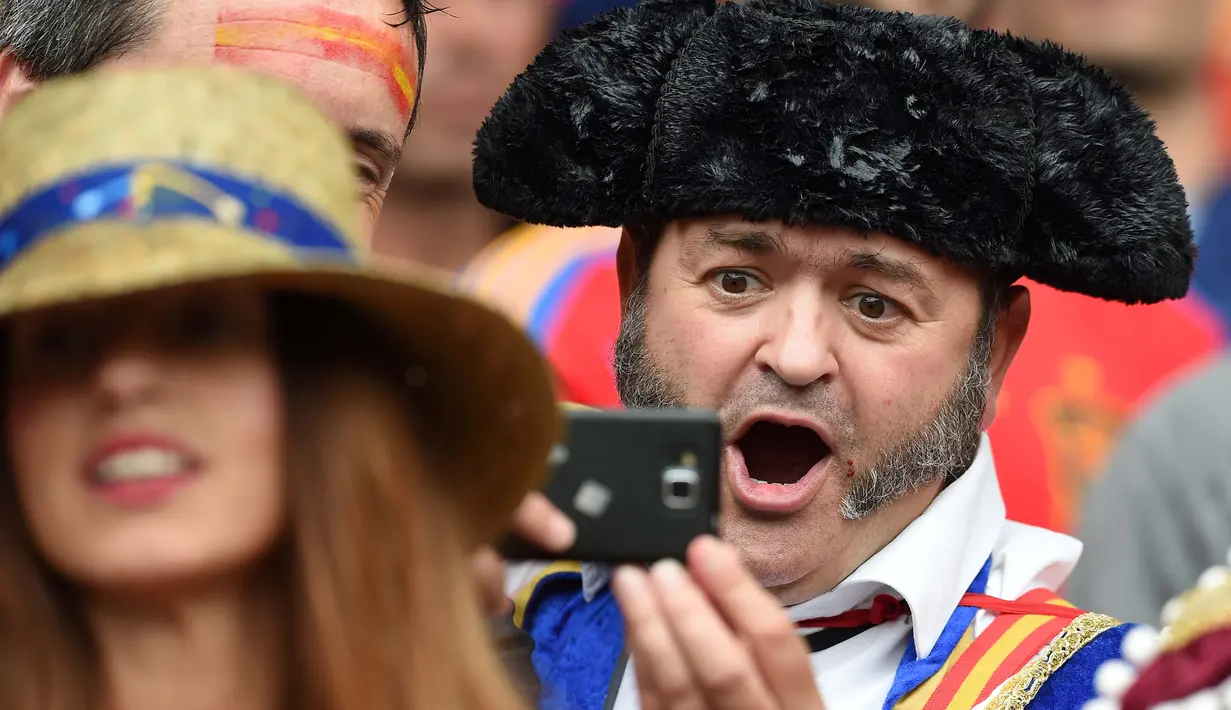 Suporter spanyol dengan pakaian khas negaranya berfoto saat menyaksikan laga Spanyol melawan Republik Ceko pada laga grup D Euro 2016 di Stadion Municipal, Toulouse, (13/6/2016). (AFP/ Nicolas Tucat)