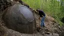 Bola batu raksasa yang ditemukan Suad Keserovic di dalam hutan Desa Podunavlje, Bosnia dan Herzegovina, Senin (11/4). Semenjak menemukan bola batu raksasa itu, Keserovic mengaku mendapat kunjungan ratusan wisatawan dari seluruh dunia. (REUTERS/Dado Ruvic)