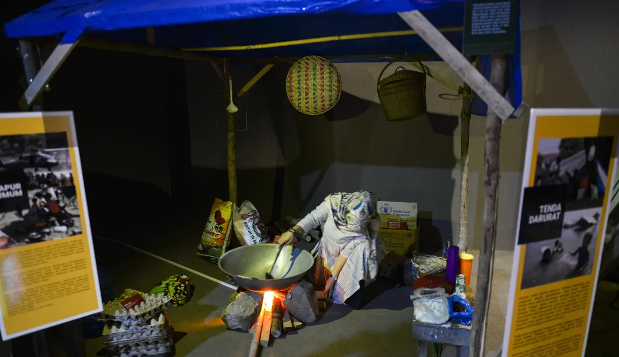 Seorang pengunjung berada di sebuah pameran yang menggambarkan sebuah dapur di tempat penampungan sementara di Museum Tsunami Aceh di Banda Aceh (19/10/2019). Gempa bumi dan tsunami Samudra Hindia 2004 menewaskan lebih dari 170.000 orang di provinsi Aceh. (AFP Photo/Chaideer Mahyuddin)