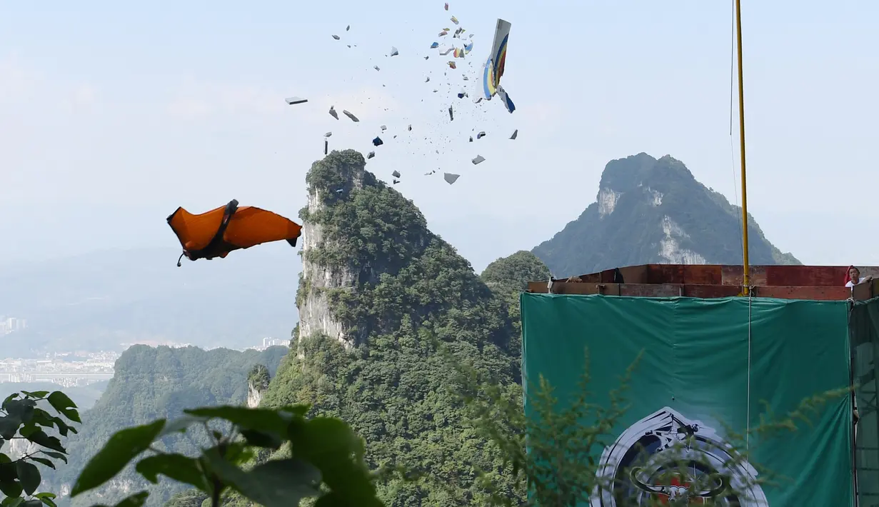 Penerjun melompat dari atas tebing mengenai target sasaran saat mengikuti Kejuaraan Dunia Wingsuit di pegunungan Tianmenshan, China, 11 September 2017. Wingsuit adalah salah satu varian baru paragliding, dengan kostum yang dilengkapi sayap.  (STR / AFP)