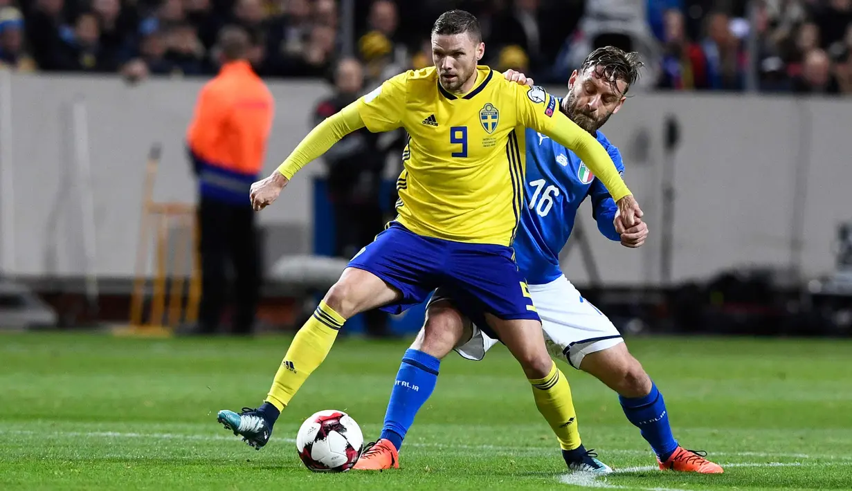 Gelandang AS Roma, Daniele De Rossi berusaha merebut bola dari pemain Swedia, Marcus Berg saat bertanding di kualifikasi Piala Dunia 2018 di Solna (10/11). Seperti Buffon De Rossi gagal mengantar Itali lolos ke Rusia. (AFP Photo/Jonathan Nackstrand)