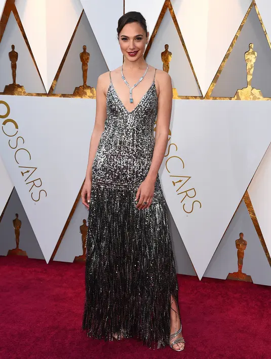 Aktris Gal Gadot berpose untuk fotografer di karpet merah Piala Oscar 2018 di Dolby Theatre, Los Angeles, Minggu (4/3). Gaun Gal Gadot hadir dengan rok model fringe yang merupakan koleksi rumah mode Givenchy. (Jordan Strauss/Invision/AP)
