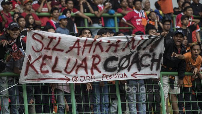 The Jakmania membentangkan spanduk yang meminta pelatih Persija Jakarta, Stefano Teco Cugurra, untuk mengundurkan diri saat laga melawan Mitra Kukar di Stadion Patriot, Bekasi, Minggu (14/5/2017). (Bola.com/Vitalis Yogi Trisna)