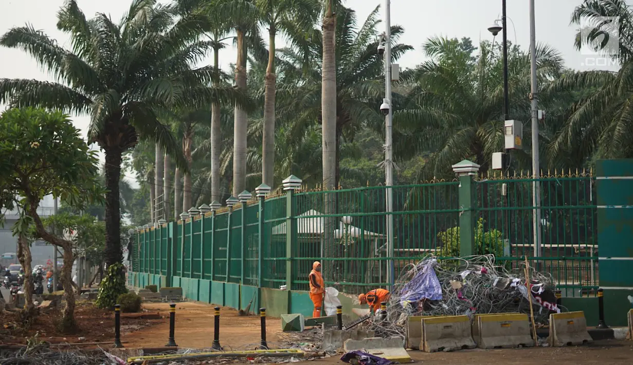 Petugas membersihkan sampah sisa bentrok antara mahasiswa dan polisi dalam unjuk rasa di depan Gedung DPR RI, Jakarta, Rabu (25/9/2019). Bentrokan pada Selasa (24/9/2019) menyisakan sampah yang memenuhi kawasan di sekitar Gedung DPR. (Liputan6.com/Immanuel Antonius)