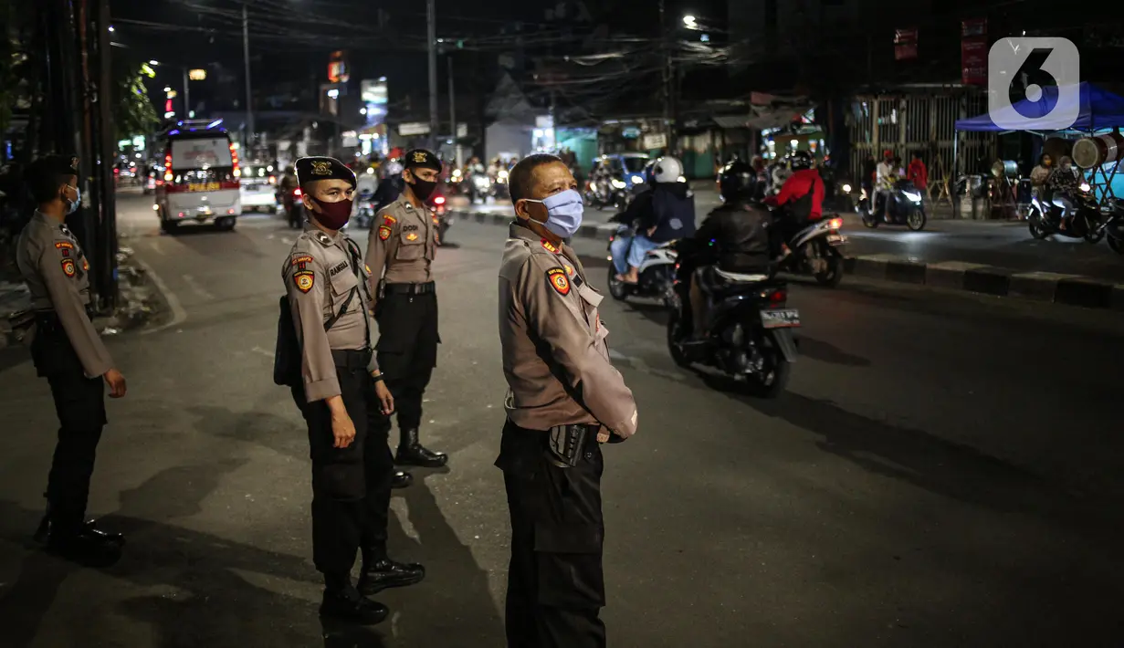 Polisi berjaga pada malam takbiran di Jalan KH Mas Mansyur, Jakarta, Sabtu (23/5/2020). Polisi dikerahkan menjaga Jalan KH Mas Mansyur untuk mengantisipasi adanya takbir keliling di kawasan tersebut. (Liputan6.com/Faiza Fanani)