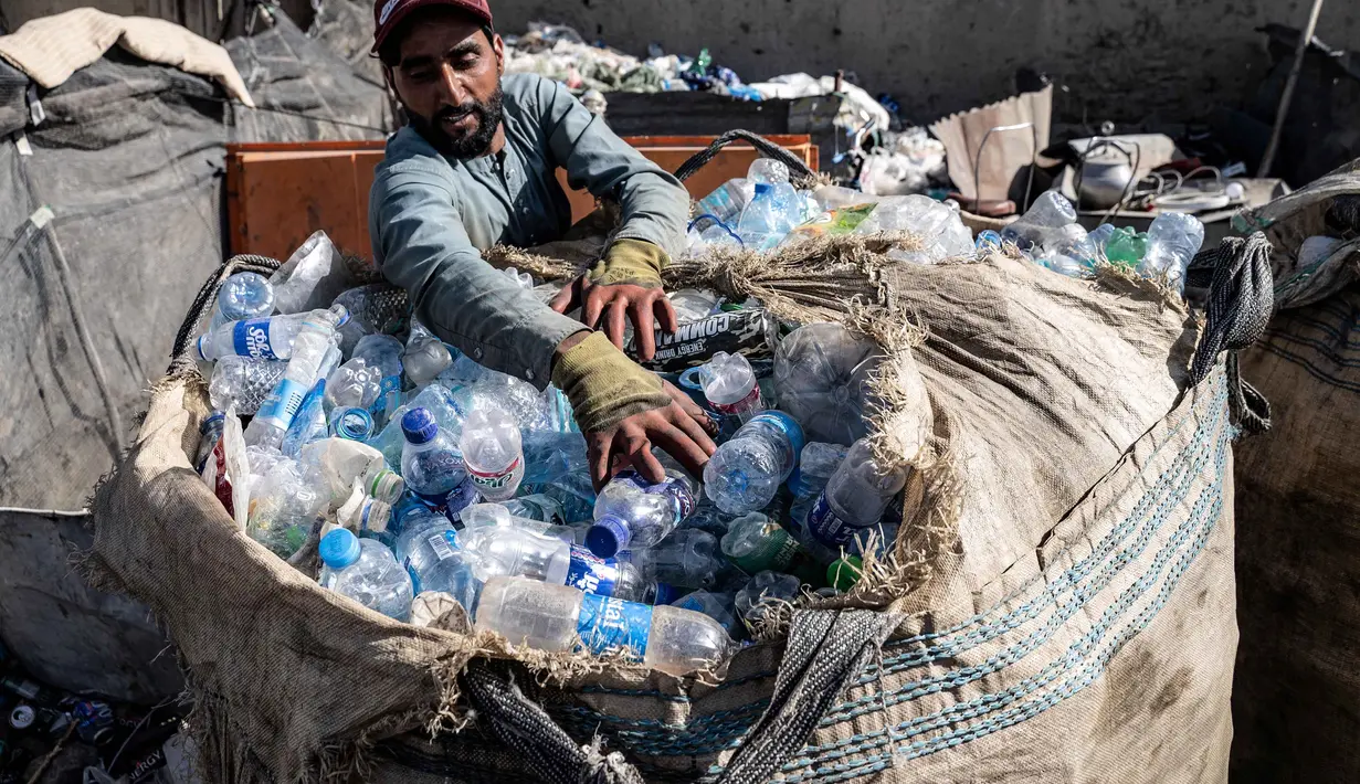 Seorang pekerja Afghanistan memasukkan botol plastik ke dalam karung di tempat daur ulang di Kabul pada 5 Agustus 2025. (Wakil KOHSAR/AFP)