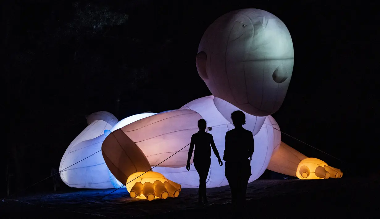 Dua foto siluet pengunjung di depan instalasi cahaya pada hari kedua Festoval Sziget di Pulau Shipyard, Budapest, Hungaria, Kamis (9/8). Festival Sziget merupakan festival seni yang berlangsung selama tujuh hari. (Marton Monus/MTI via AP)