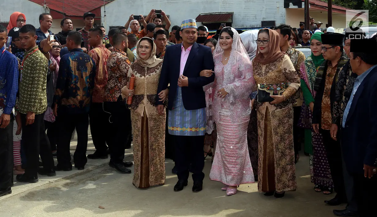 Putri Presiden Joko Widodo, Kahiyang Ayu dan Bobby Nasution mesra bergandengan setibanya di rumah paman sang suami, di Medan, Selasa (21/11). Bobby dan Kahiyang diiringi oleh pihak keluarga masuk ke lokasi acara pemberian marga. (Liputan6.com/Johan Tallo)