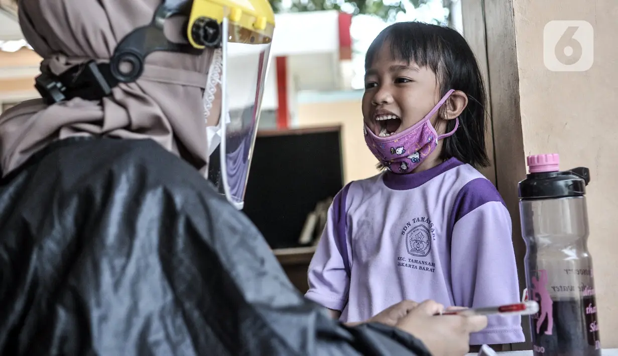 Petugas paramedis memeriksa kesehatan gigi salah seorang anak sebelum mengikuti program BIAS di Kantor Kelurahan Tamansari, Jakarta, Selasa (24/11/2020). BIAS dilakukan dengan konsisten menerapkan protokol kesehatan COVID-19. (merdeka.com/Iqbal S. Nugroho)