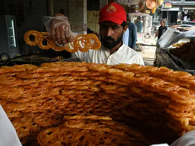 Seorang tukang roti menyiapkan makanan buka puasa Jalebi di sebuah toko di Islamabad, Pakistan, Kamis (23/3/2023). (Aamir QURESHI/AFP)