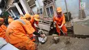Petugas PPSU Kelurahan Kampung Melayu Siti Hajar bersama rekan-rekannya membersihkan sisa lumpur akibat banjir yang melanda Kebon Pala, Jakarta, Kamis (25/4). (Liputan6.com/Herman Zakharia)