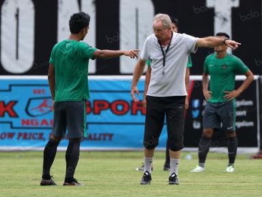 Alfred Riedl saat menjelaskan strategi menyerang kepada Bayu Pradana pada sesi latihan di Stadion Maguwoharjo, Sleman, Jumat (07/10/2016). (Bola.com/Nicklas Hanoatubun)