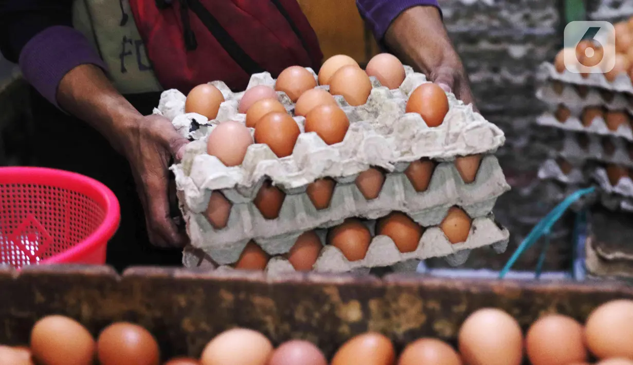 Pedagang memindahkan telur ayam dagangannya di Pasar Kelapa Dua, Kabupaten Tangerang, Banten, Rabu (29/12/2021). Meroketnya harga telur ayam di sejumlah wilayah jelang pergantian tahun dipicu oleh harga pakan yang tinggi. (Liputan6.com/Angga Yuniar)