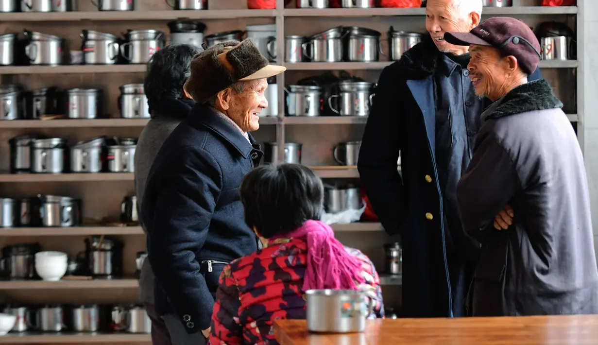 Orang-orang berbincang di depan rak peralatan makan di sebuah kantin untuk warga lanjut usia (lansia) di Desa Yingshan, Kota Quanzhou, Provinsi Fujian, China pada 17 Desember 2020. Kantin lansia dikelola menggunakan donasi lokal, dengan para warga lokal yang menjadi sukarelawan. (Xinhua/Wei Peiquan