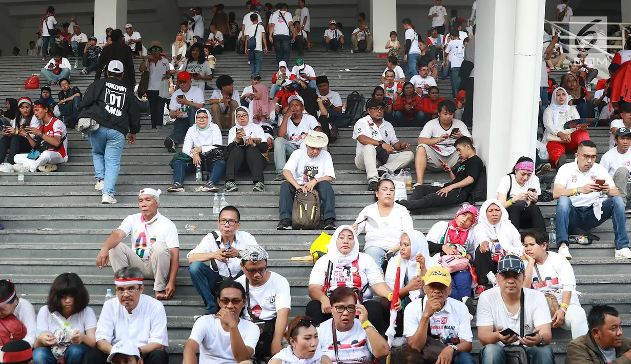 Massa pendukung paslon nomor urut 01 menggelar nonton bareng Konser Putih Bersatu di luar Stadion GBK, Jakarta, Sabtu (13/4). Tingginya antusiasme warga menghadiri kampanye akbar Jokowi-Ma'ruf Amin membuat SUGBK penuh hingga warga terpaksa menonton dari luar stadion. (Liputan6.com/Immanuel Antonius)