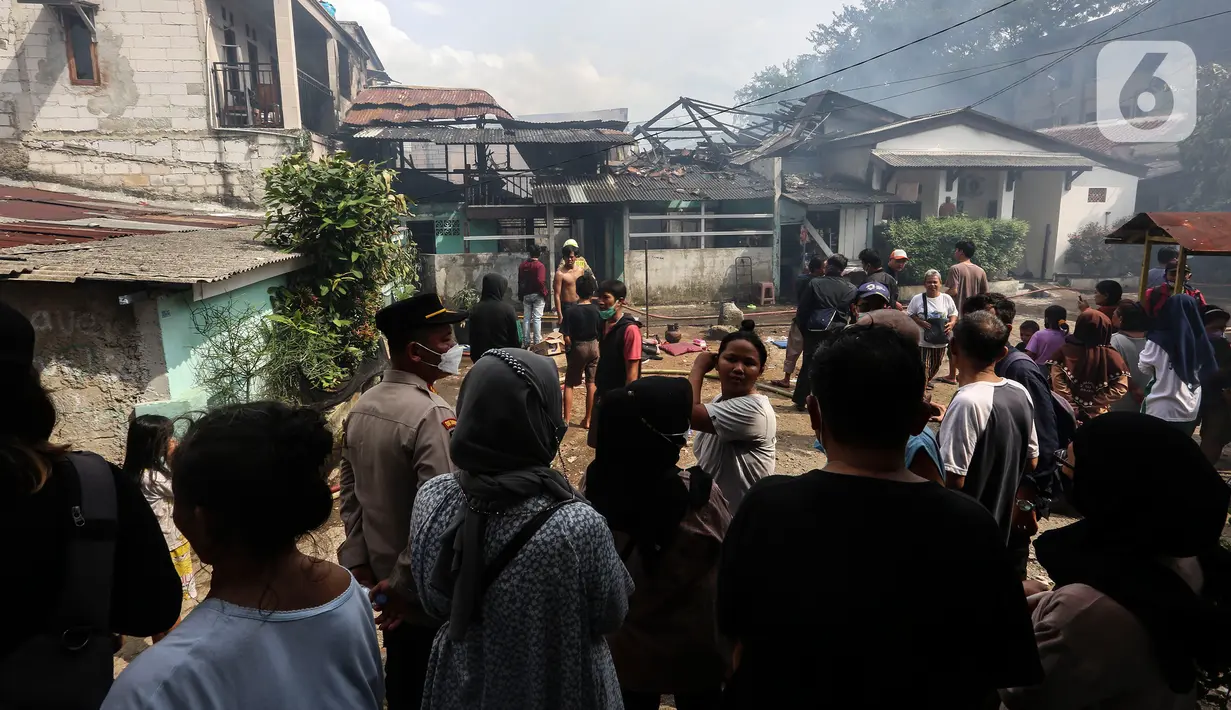 Sejumlah orang menyaksikan petugas pemadam kebakaran yang melakukan proses pendinginan pada permukiman penduduk yang terbakar di Jalan Masjid Alhuda atau depan Stasiun Kebayoran Lama RT 05/01, Jakarta Selatan, Selasa (24/5/2022).  Petugas pun mengerahkan 27 unit mobil pemadam kebakaran dari Sudin Damkar Jakarta Selatan ke lokasi kejadian. (Liputan6.com/Johan Tallo)