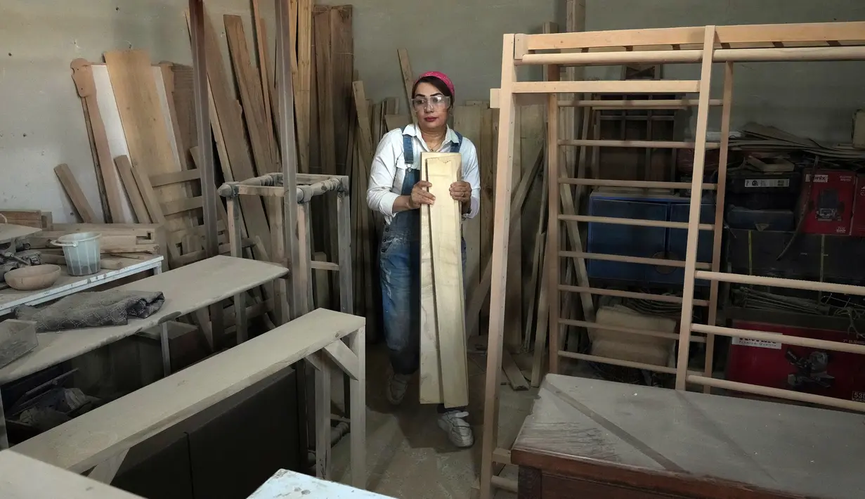 Tukang kayu Iran Sahar Biglari memindahkan kayu saat bekerja di bengkelnya di Teheran, Iran, 12 Maret 2023. Secara tradisional, tukang kayu di Iran merupakan profesi yang didominasi laki-laki. (AP Photo/Vahid Salemi)