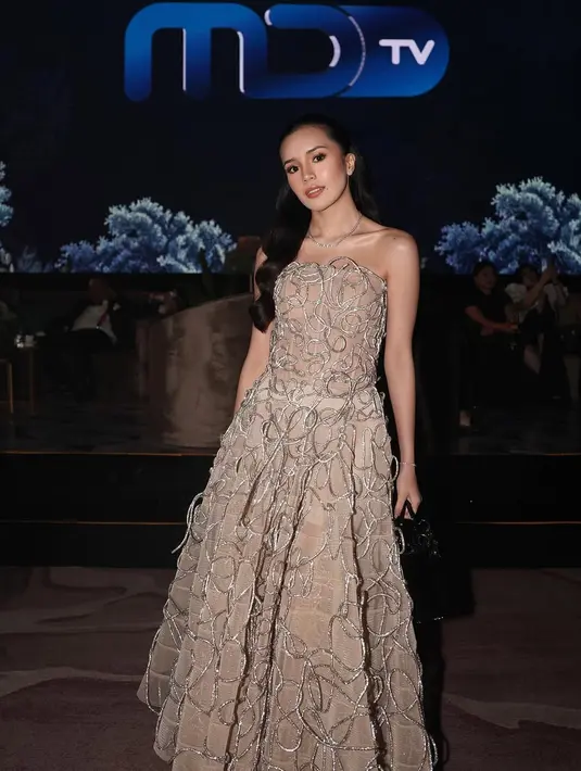 Beby Tsabina tampil memesona dalam nude strapless dress dengan aksen bordiran salur yang memberikan kesan mewah dan feminin. [@bebytsabina].