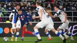 Pemain Finlandia Niko Hamalainen (kiri) dan pemain Prancis Kylian Mbappe bersaing memperebutkan bola pada pertandingan sepak bola kualifikasi Grup D Piala Dunia 2022 di Stadion Olimpiade, Helsinki, Finlandia, 16 November 2021. Prancis menang 2-0. (FRANCK FIFE/AFP)