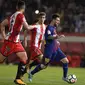 Bintang Barcelona, Lionel Messi, berusaha melewati bek Girona, Juanpe Ramirez, pada laga La Liga Spanyol di Stadion Montilivi, Girona, Sabtu (23/9/2017). Girona kalah 0-3 dari Barcelona. (AFP/Josep Lago)