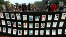 Aktivis menunjukkan foto para korban HAM saat aksi Kamisan ke-502 di seberang Istana Merdeka, Jakarta, Kamis (10/8). Aksi meminta pemerintah mewujudkan komitmen dalam menyelesaikan kasus pelanggaran HAM berat pada masa lalu. (Liputan6.com/Johan Tallo)