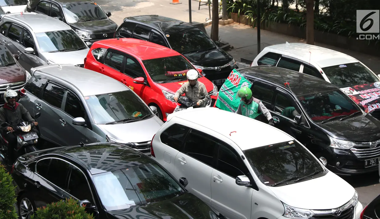 Salah satu pengendara motor mencoba menembus jejeran kendaraan taksi online yang berjejer di jalan Iskandarsyah menuju Terminal Blok M, Jakarta, Selasa (25/9). Mereka berunjuk rasa di depan Kantor GO-JEK Indonesia. (Liputan6.com/Helmi Fithriansyah)