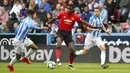 Gelandang Manchester United, Paul Pogba, berusaha melewati pemain Huddersfield Town pada laga Premier League di Stadion John Smith, Minggu (5/5). Kedua tim bermain imbang 1-1. (AP/Anthony Devlin)