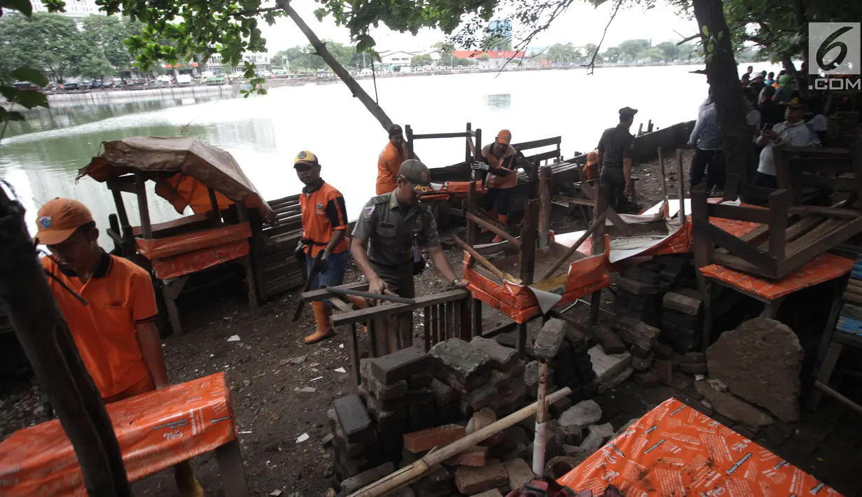 Petugas Penanganan Sarana dan Prasarana Umum (PPSU) DKI Jakarta membongkar lapak pedagang di kawasan Danau Sunter, Jakarta Utara, Jumat (19/1). Penataan ini dilakukan untuk mendukung Festival Danau Sunter pada Februari 2018. (Liputan6.com/Arya Manggala)