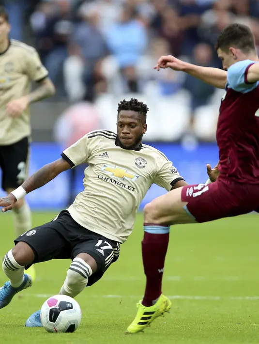 Gelandang Manchester United, Fred berusaha merebut bola yang dibawa pemain West Ham, Declan Rice selama pertandingan lanjutan Liga Inggris di stadion London (22/9/2019). West Ham menang 2-0 atas Manchester United. (AP Photo/Nigel French)