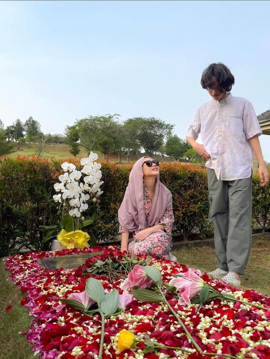 <p>BCL mengenakan pakaian cerah berwarna merah muda sementara Noah memakai koko putih. Keduanya kembali menghiasi makam Ashraf dengan bunga. (Foto: Instagram/ itsmebcl)</p>