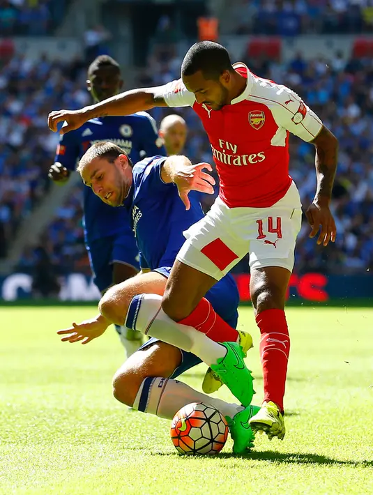 Bek Chelsea, Branislav Ivanovic (kiri) berusaha merebut bola dari gelandang Arsenal, Theo Walcott pada pertandingan FA Community Shield di Wembley Stadium, Minggu (2/8/2015). Arsenal menang atas Chelsea dengan skor 1-0. (Reuters/Darren Staples)