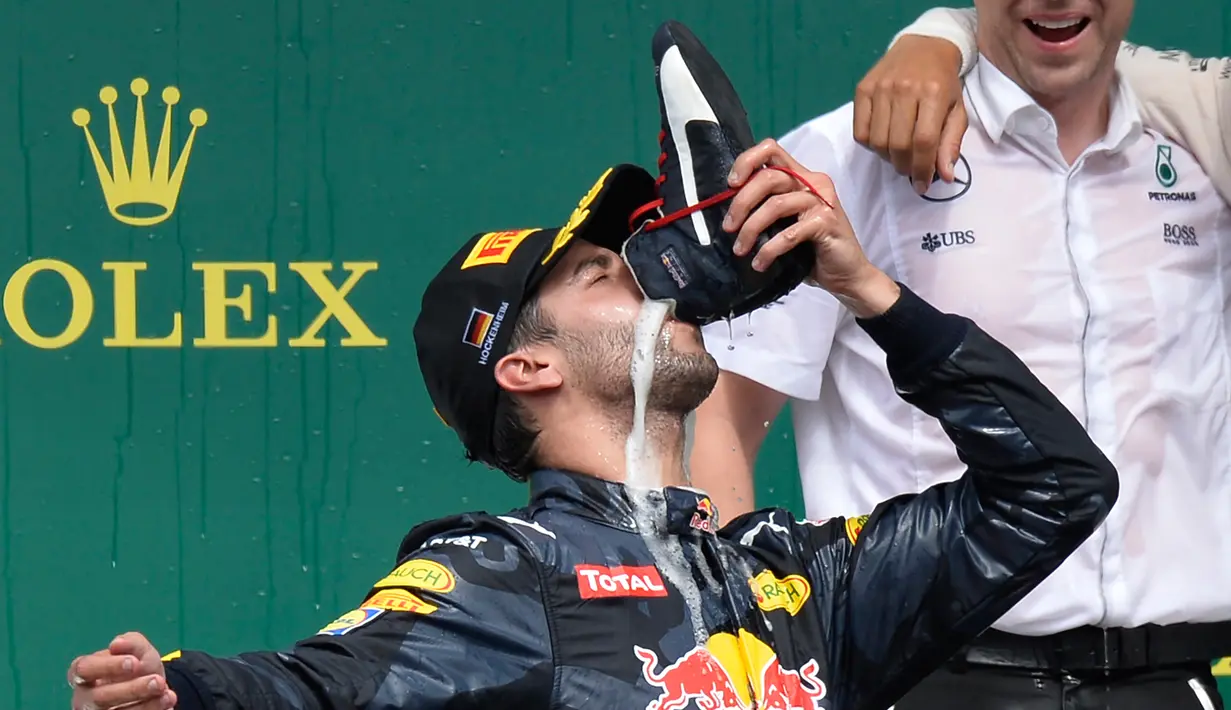 Ekspresi pembalap Red Bull Daniel Ricciardo ketika meminum sampanye dengan menggunakan sepatunya di atas podium pada selebrasi kemenangan selama Grand Prix Formula 1 Jerman, Minggu (31/7). Pembalap asal Australia itu menjadi juara dua (THOMAS KIENZLE/AFP)