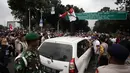 Seorang wanita naik di atas mobil taksi online yang melintas saat unjuk rasa di depan Istana Negara, Jakarta, Rabu (14/2). Kericuhan nyaris terjadi lantaran demonstran mencegat para driver online yang masih beroperasi. (Liputan6.com/Arya Manggala)