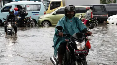 Sejumlah kendaraan bermotor nekat melintasi Jalan Matraman, Jakarta,  yang digenangi air, Sabtu (27/12/2014). (Liputan6.com/Miftahul Hayat)