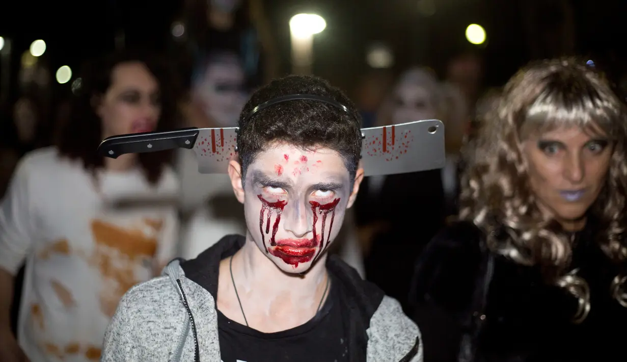 Seorang remaja berdandan serta mengenakan kostum zombie saat mengikuti Zombie Walk dalam Festival Purim di Tel Aviv, Israel (3/3). Acara pesta kostum zombie ini dimeriahkan oleh ratusan orang di Tel Aviv. (AP Photo/Ariel Schalit)