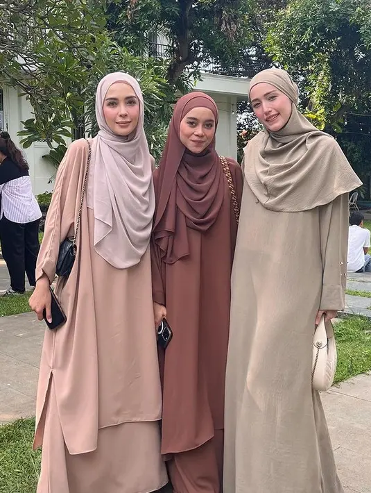 Adelia Pasha tampil mengenakan dress panjang dan khimar. Sambil membawa handbag putih. [@adeliapasha]