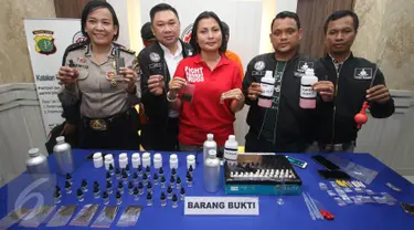 Kasat Narkoba Polres Jakarta Selatan Kompol Vivick Tjangkung menunjukkan tersangka beserta barang bukti kasus cairan rokok elektrik berbahan ganja di Mapolres Jakarta Selatan, Selasa (21/3). (Liputan6.com/Immanuel Antonius)