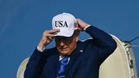 Presiden AS Donald Trump saat keluar dari Air Force One, yang mendarat di bandara Schiphol, Amsterdam, untuk menghadiri pertemuan puncak NATO di Den Haag, pada 24 Juni 2025. (Brendan Smialowski/AFP)