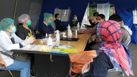 Petugas kesehatan di Posko Tanggap Darurat Corona Covid-19 Kota Malang bersiap memeriksa kesehatan para santri yang baru pulang dari pondok pesantren (Liputan6.com/Zainul Arifin)