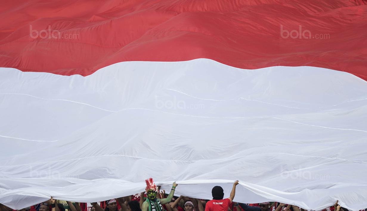 Suporter membentangkan merah putih raksasa saat laga Timnas Indonesia melawan Timor Leste pada laga SEA Games di Stadion MPS, Selangor, Minggu (20/8/2017). Indonesia menang 1-0 atas Timor Leste. (Bola.com/Vitalis Yogi Trisna)