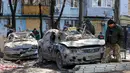 Seorang pria berjalan melewati mobil-mobil yang rusak di sebelah bangunan tempat tinggal berlantai lima yang hancur setelah serangan rudal di tengah invasi Rusia ke Ukraina di Zaporizhzhia pada 2 Maret 2023. Di antara mereka yang selamat adalah seorang pria berusia 30 tahun yang menurut petugas penyelamat terjebak di bawah lempeng beton akibat serangan rudal. (AFP/Katerina Klochko)