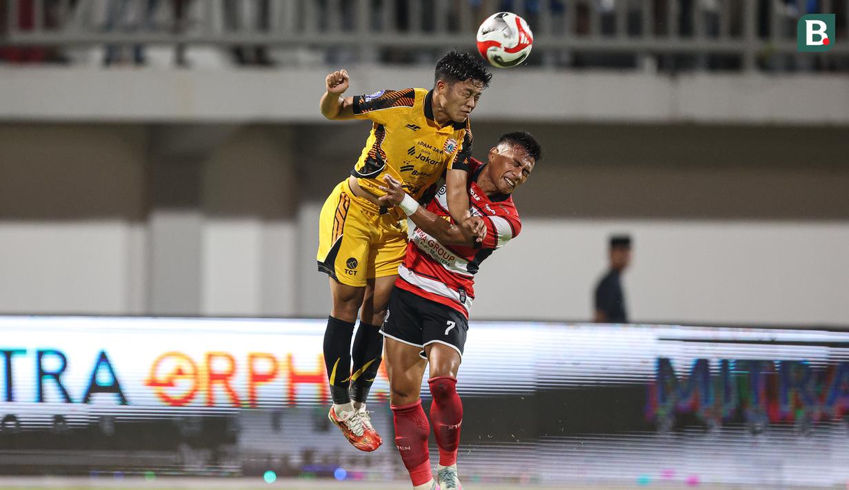 Pemain Persija Jakarta, Rio Fahmi (kiri) berduel dengan pemain Madura United pada lanjutan BRI Super League 2025/2026 di Stadion Gelora Ratu Pamelingan, Jumat (24/10/2025) malam WIB. (Bola.com/Abdul Aziz).