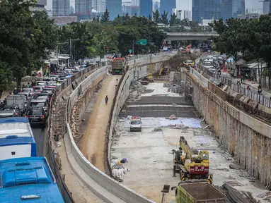 Sejumlah kendaraan melintas di samping proyek pembangunan underpass Mampang-Kuningan di kawasan Mampang, Jakarta, Rabu (27/12). Pengerjaan proyek yang kini telah mencapai 80 persen tersebut ditargetkan selesai pada April 2018. (Liputan6.com/Faizal Fanani)