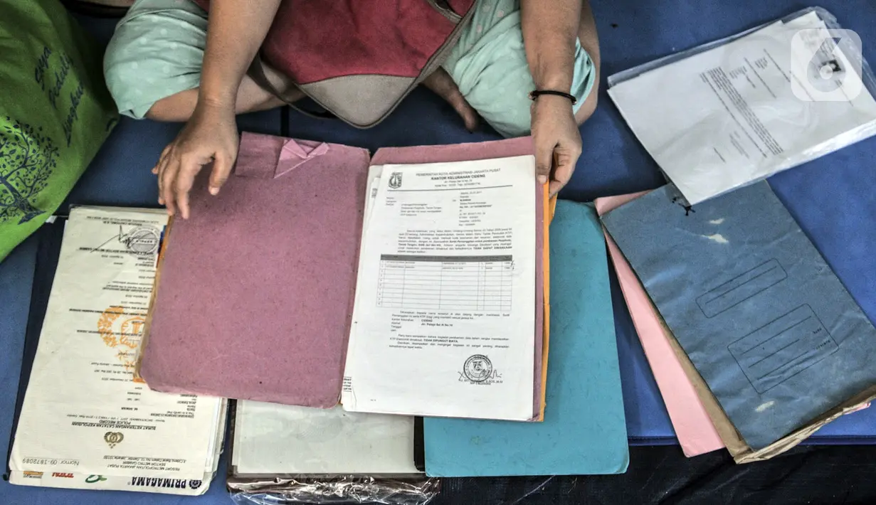 Salah seorang korban kebakaran menunjukkan surat-surat yang berhasil diselamatkan di salah satu kelas SMP PGRI 32, Cideng, Jakarta, Minggu (8/11/2020). Kebakaran menyebabkan seluruh barang milik warga hangus sekejap, kecuali surat-surat yang dapat terselamatkan. (merdeka.com/Iqbal Septian Nugroho)