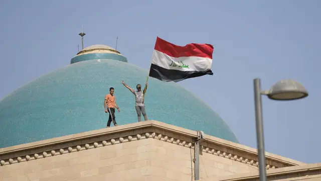 Dua orang pria di atas Istana Kepresidenan di Irak.