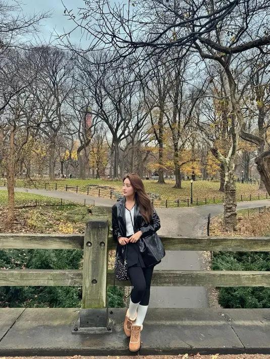 Ia memadukan leather blazer dengan v-neck top dan long pants nuansa monokrom. Penampilannya dilengkapi dengan kaus kaki panjang, sepatu boots, dan kacamata hitam. [@natashawilona12]