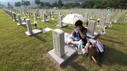 Warga Korea Selatan,Oh Myung-Soon menangis di depan batu nisan saudaranya yang meninggal selama Perang Korea di pemakaman nasional, Seoul, Korea Selatan, Rabu (6/6). Kegiatan ini dilakukan dalam Memorial Day. (AP Photo/Ahn Young-joon)