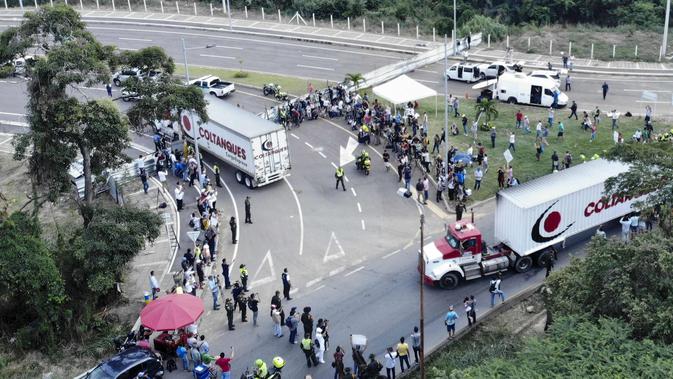 Truk-truk bantuan kemanusiaan untuk Venezuela menuju Jembatan Tienditas di perbatasan Kolombia-Venezuela, Cucuta, Kolombia, Kamis (7/2). Kedatangan bantuan ini disambut gembira oleh sekelompok migran Venezuela. (Edinson ESTUPINAN/AFP)