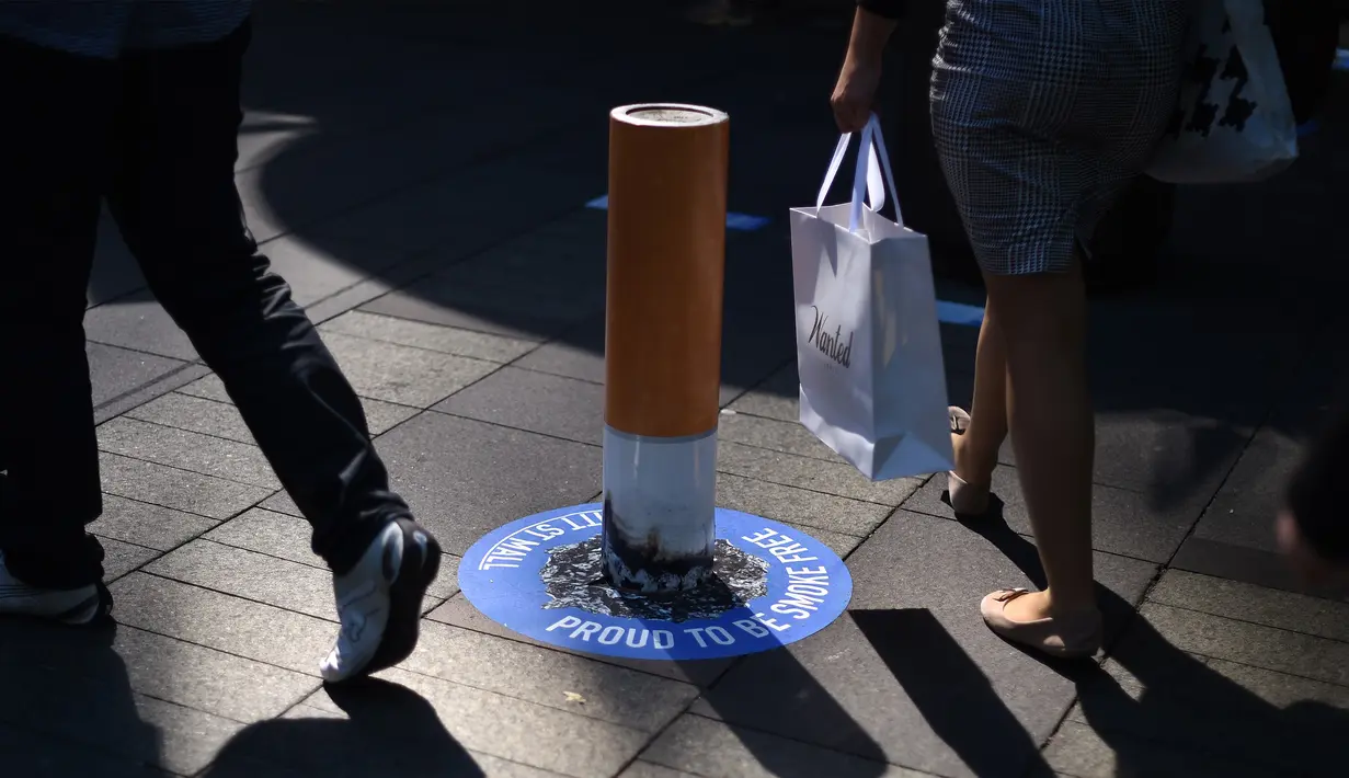 Sejumlah orang hilir mudik di sekitar puntung rokok raksasa di kawasan Pitt Street Mall, Sydney, Australia, Senin (26/9). Puntung rokok raksasa tersebut sebagai kampanye untuk kawasan bebas asap rokok di Sydney. (AFP PHOTO/Saeed Khan)